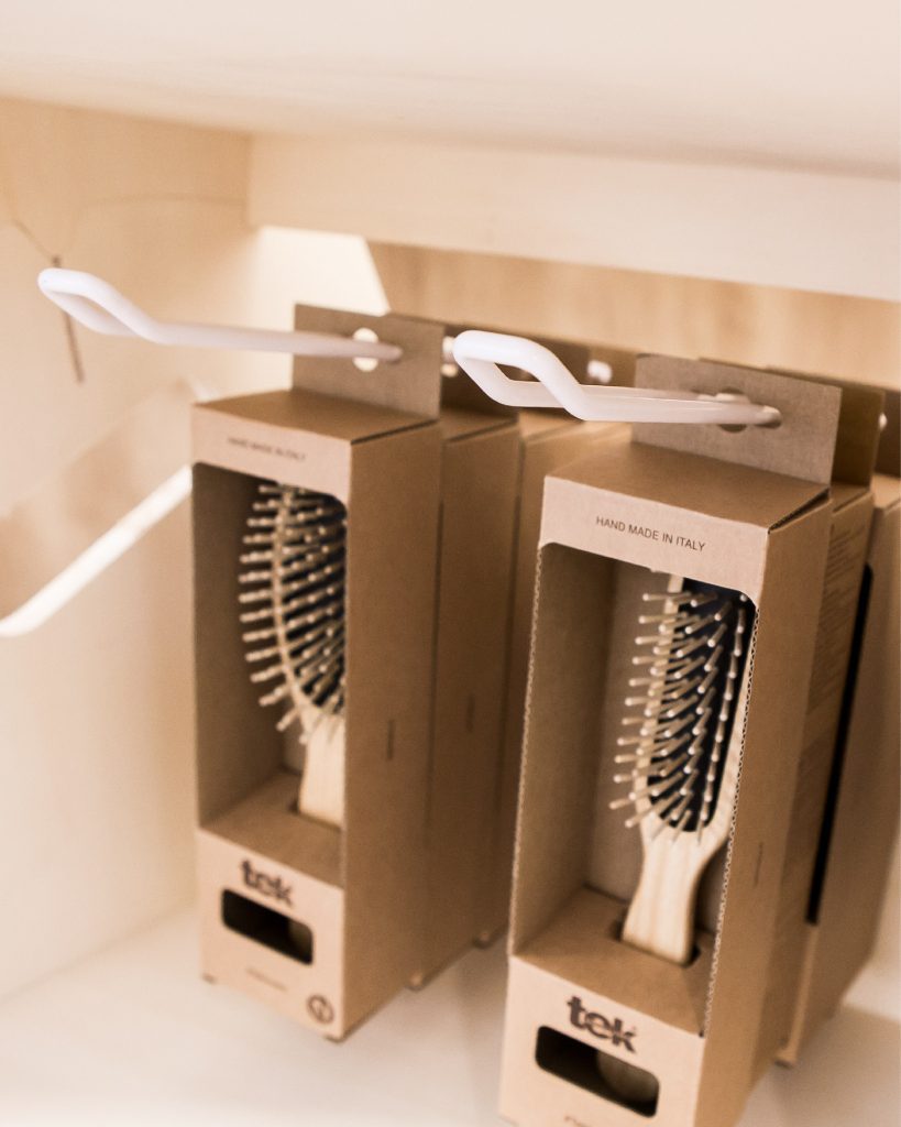 Vue rapprochée d'une broche double supportant des boîtes de brosses en bois fabriquées en Italie.