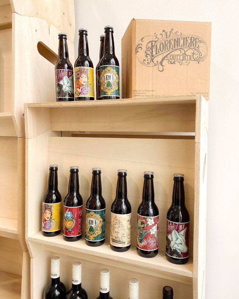 Présentoir en bois avec une sélection de bières artisanales et un carton de brasserie