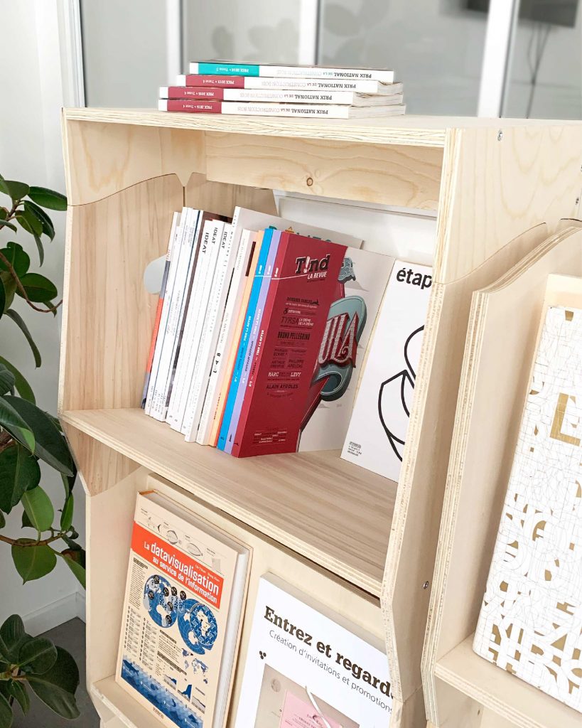 Présentoir en bois modulable avec des livres et brochures exposés, idéal pour librairies et espaces de lecture.
