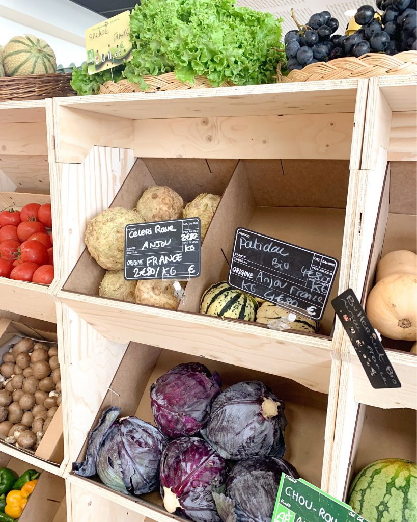 Présentoir en bois modulable exposant des fruits et légumes frais dans une épicerie, conçu par IZZIBOX.