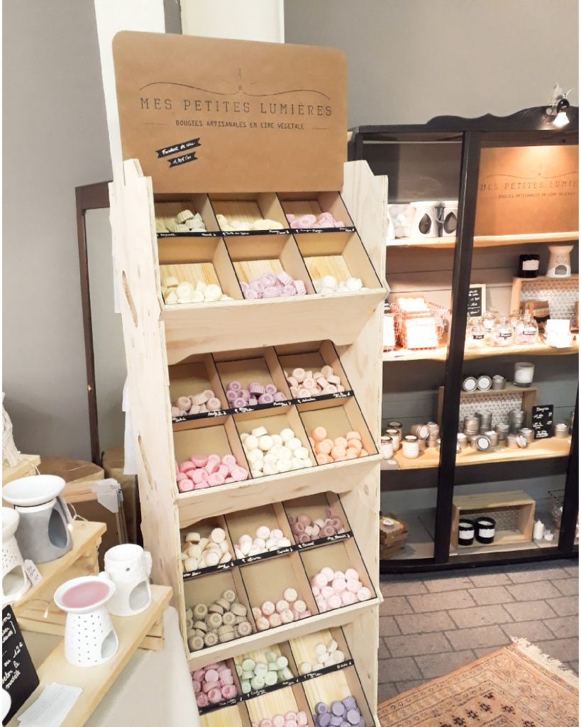 Présentoir en bois modulable exposant des savons artisanaux et bougies dans une boutique, conçu par IZZIBOX.