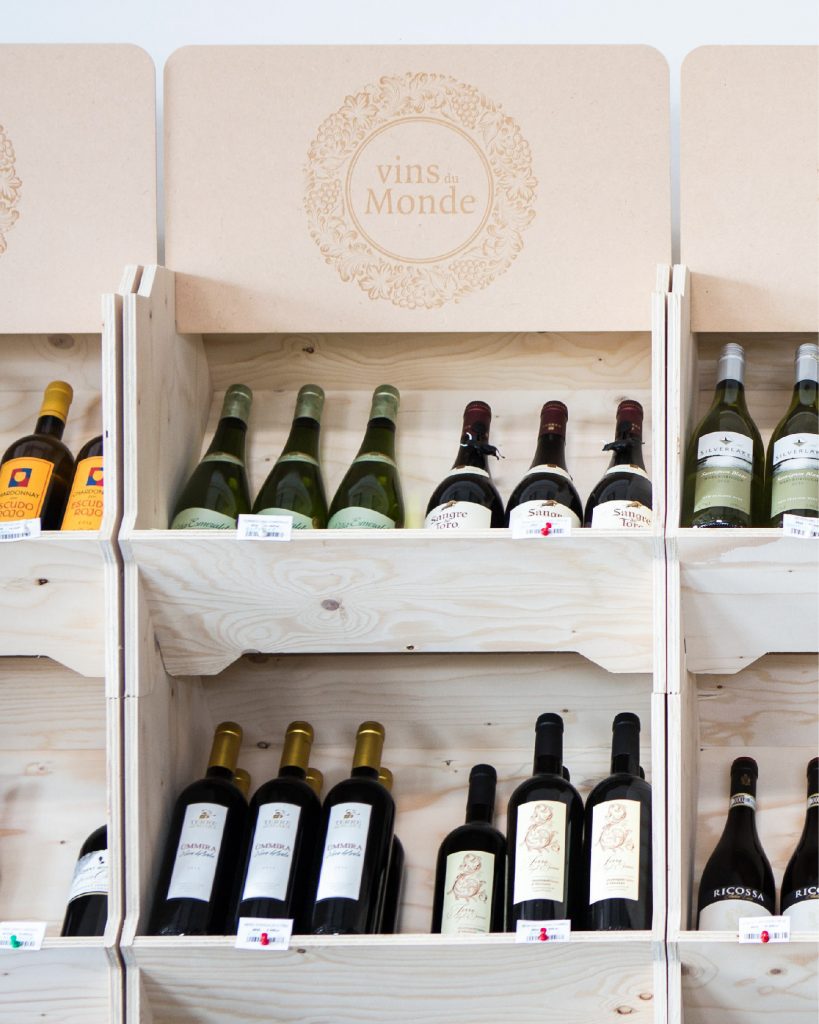 Range-bouteilles modulable en bois exposant des vins du monde dans une boutique spécialisée, conçu par IZZIBOX.