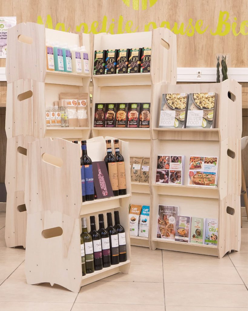 Présentoirs modulables en bois exposant des produits bio et locaux dans une épicerie, conçus par IZZIBOX.